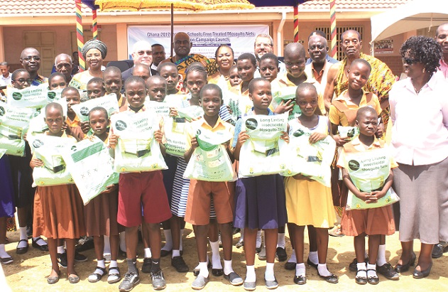A section of the beneficiaries displaying their nets in a group photograph with some dignitaries